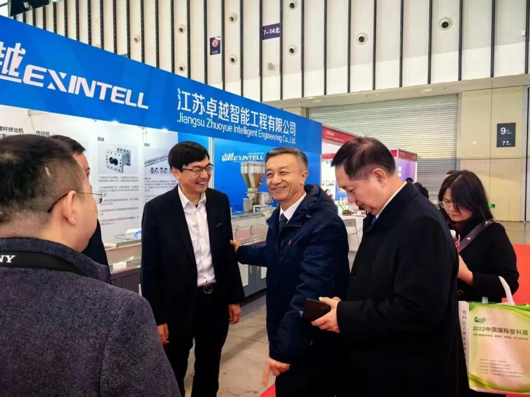 International trade exhibition hall with industrial machinery displays and B2B buyers evaluating manufacturing equipment