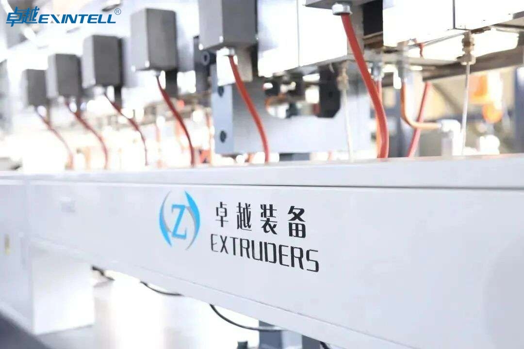 Pellets of PVC, polypropylene, and engineering resins arranged beside extruded plastic profiles on a factory workbench